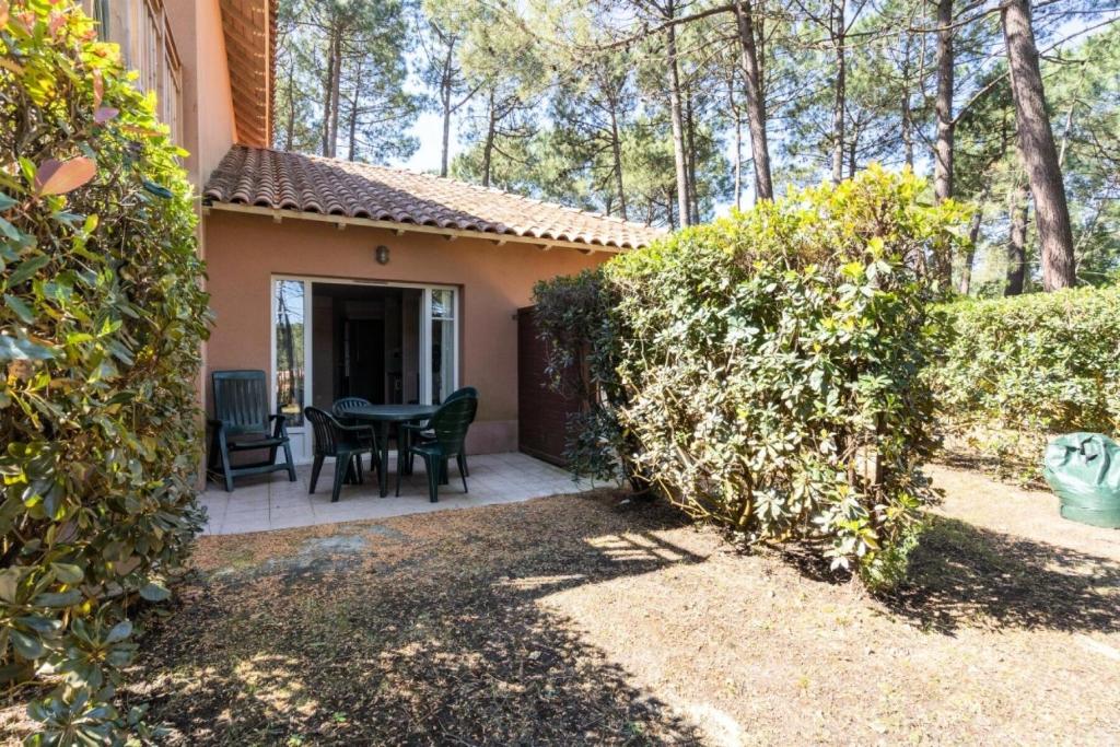 un patio d'une maison avec une table et des chaises dans l'établissement Résidence Lacanau Les Pins - maeva Home - Studio 5 Personnes - Sélection MAE-7452, à Lacanau