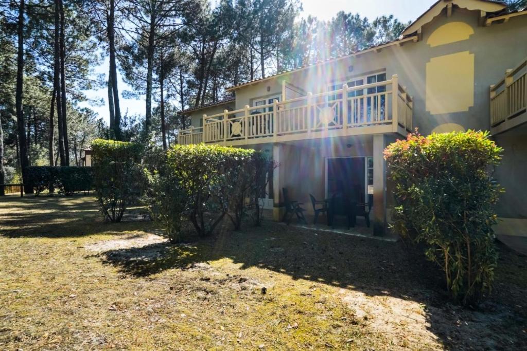 une maison avec un balcon et une cour dans l'établissement Résidence Lacanau Les Pins - maeva Home - Appartement 2 Pièces 4 Personnes - Sélection MAE-7453, à Lacanau