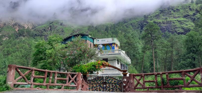 a house on top of a mountain with a fence at Destination of peace kasol in Kasol