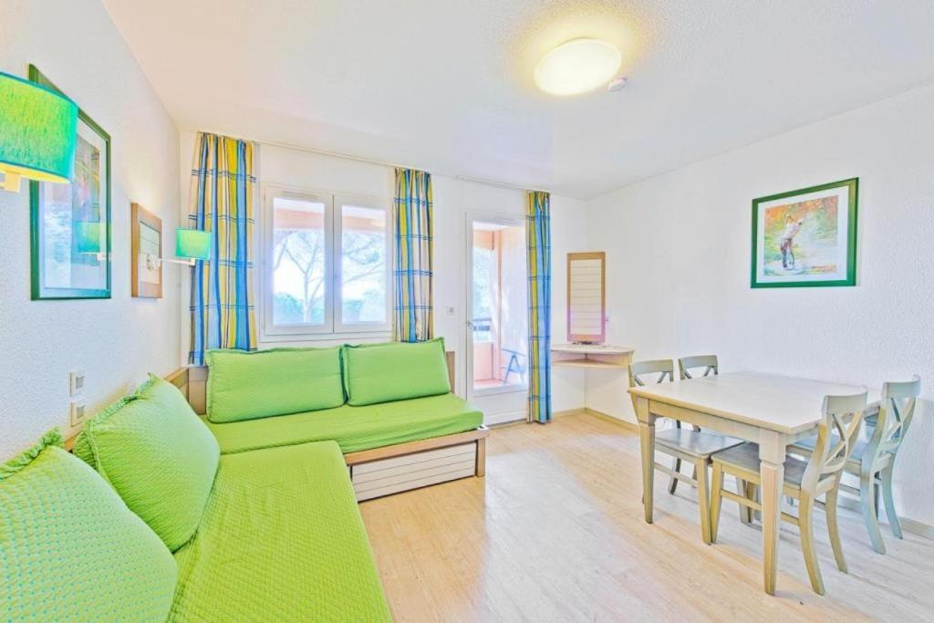 un salon avec un canapé vert et une table dans l'établissement Résidence Saint-Raphaël Valescure - maeva Home - Studio 4 Personnes Sélection MAE-5601, à Valescure