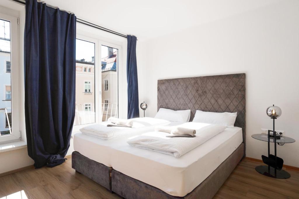 a large bed in a room with a large window at easy flat Villach main plaza in Villach