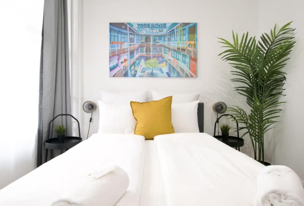 a bedroom with a white bed with a yellow pillow at Studio Apartments by Hi5- Apartment in Downtown in Budapest