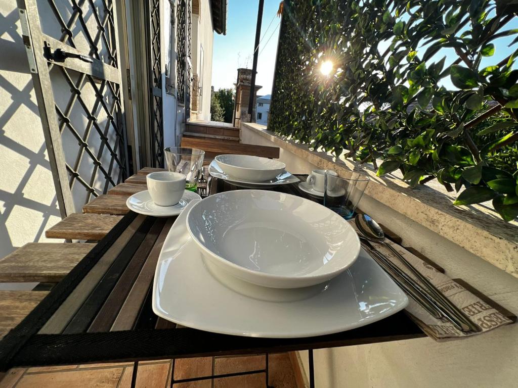 a table with bowls and plates on a balcony at Oasi di Mare next Rome Airport in Fregene