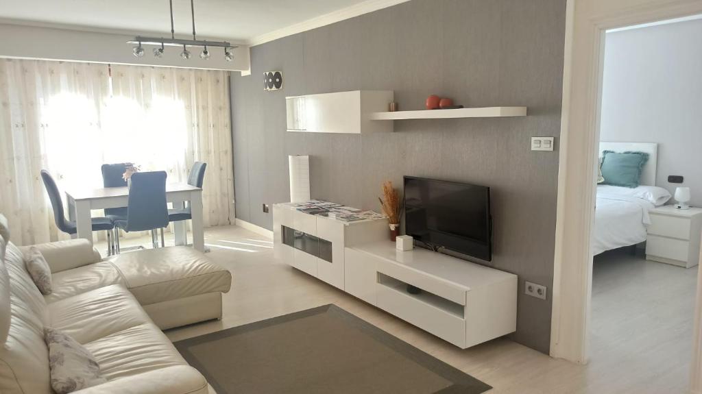 ein Wohnzimmer mit einem Sofa und einem TV in der Unterkunft Ohana, Apartamento-CENTRICO-WIFI-ASCENSOR- PARKING PRIVADO GRATIS-SIN CUESTAS in Bermeo