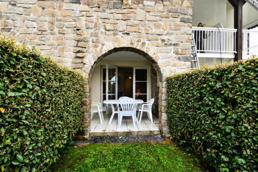 d'une terrasse avec une table et des chaises dans un mur en pierre. dans l'établissement Résidence Port du Crouesty - maeva Home - Appartement 2 pièces 4 personnes - Sélection - super Home MAE-1644, à Arzon