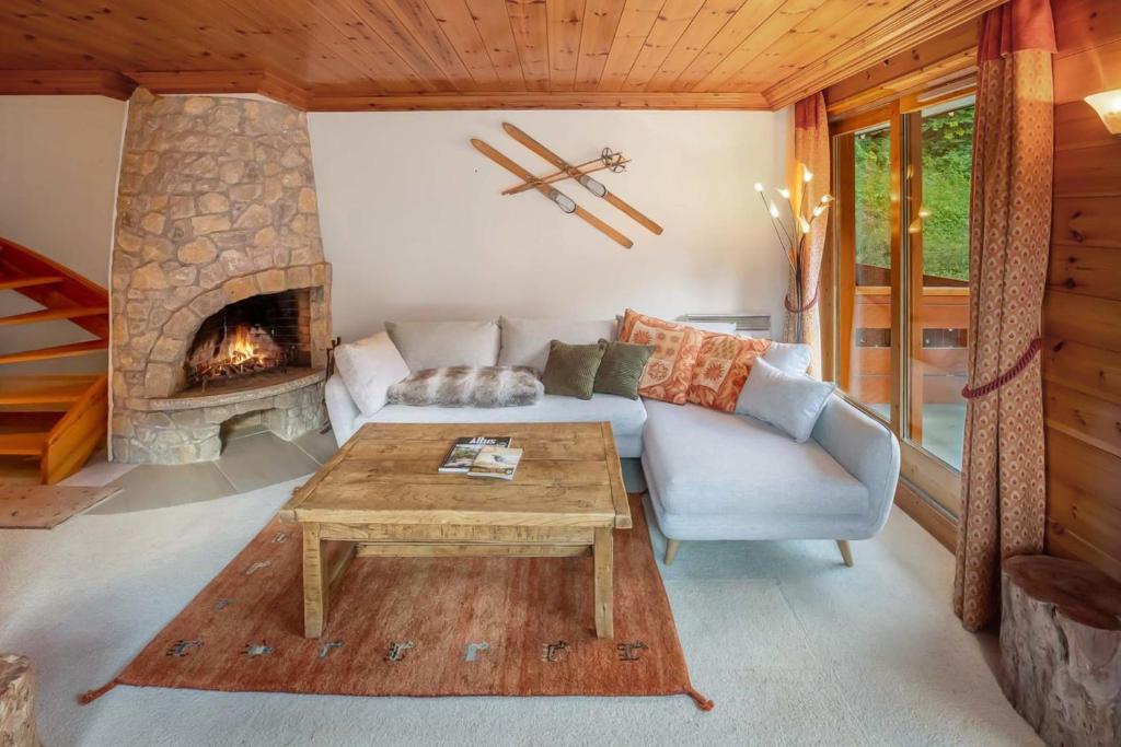 Una sala de estar con un sofá y una chimenea. en Grand Duc 8, en Méribel