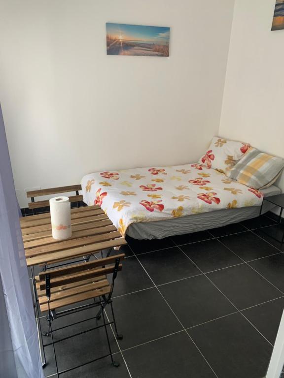 a small bedroom with a bed and a table at Jolie maisonnette avec terrasse Nancy centre in Nancy