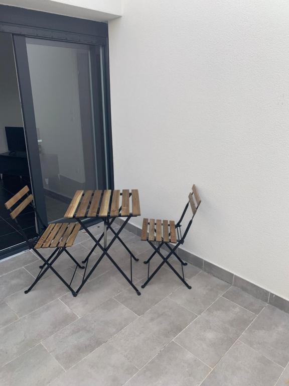 two chairs sitting next to a white wall at Jolie maisonnette avec terrasse Nancy centre in Nancy