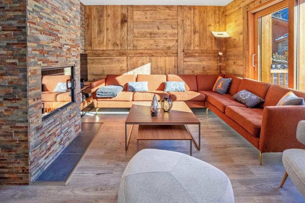a living room with a couch and a brick wall at Chalet de l'Olympe A2 in Les Allues