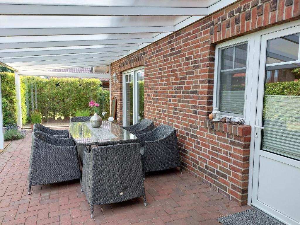 a patio with a table and chairs on a brick wall at Villa FH Mechthild in Dörpen