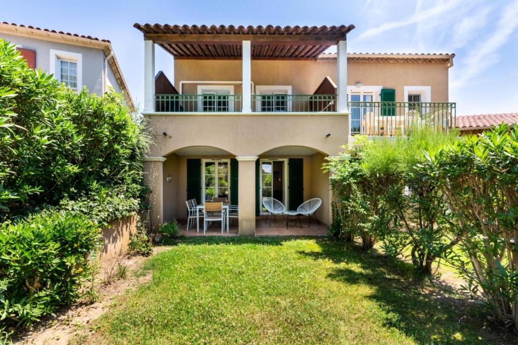 une maison avec un balcon et une cour dans l'établissement Résidence Les Rivages du Lac - maeva Home - Appartement cosy 3 pièces 6 personnes - Prestige - super Home MAE-0654, à Drammont