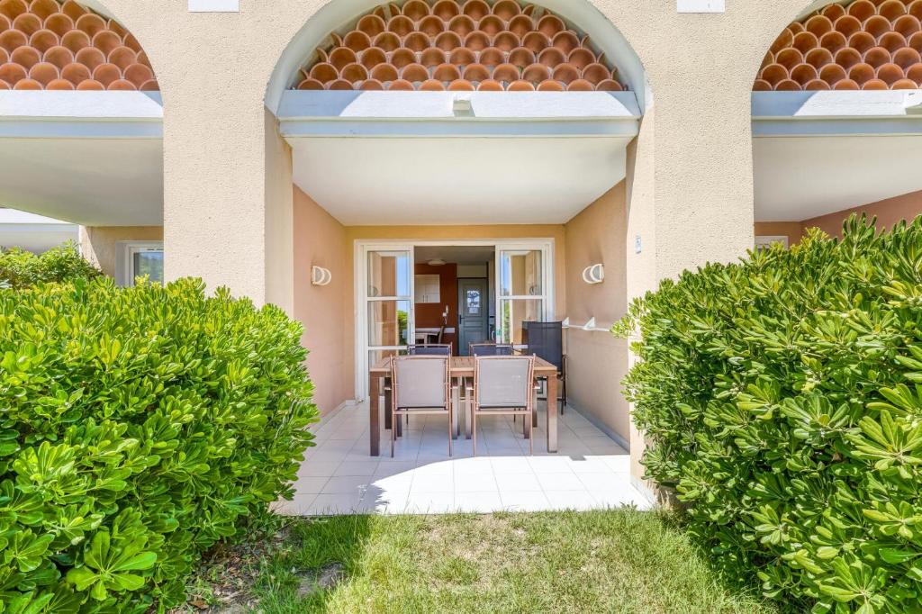 une terrasse avec une table et des chaises dans une maison dans l'établissement Résidence le Village de Cap Esterel - maeva Home - Appartement 2 Pièces 5 Personnes - Confort MAE-1074, à Saint-Raphaël