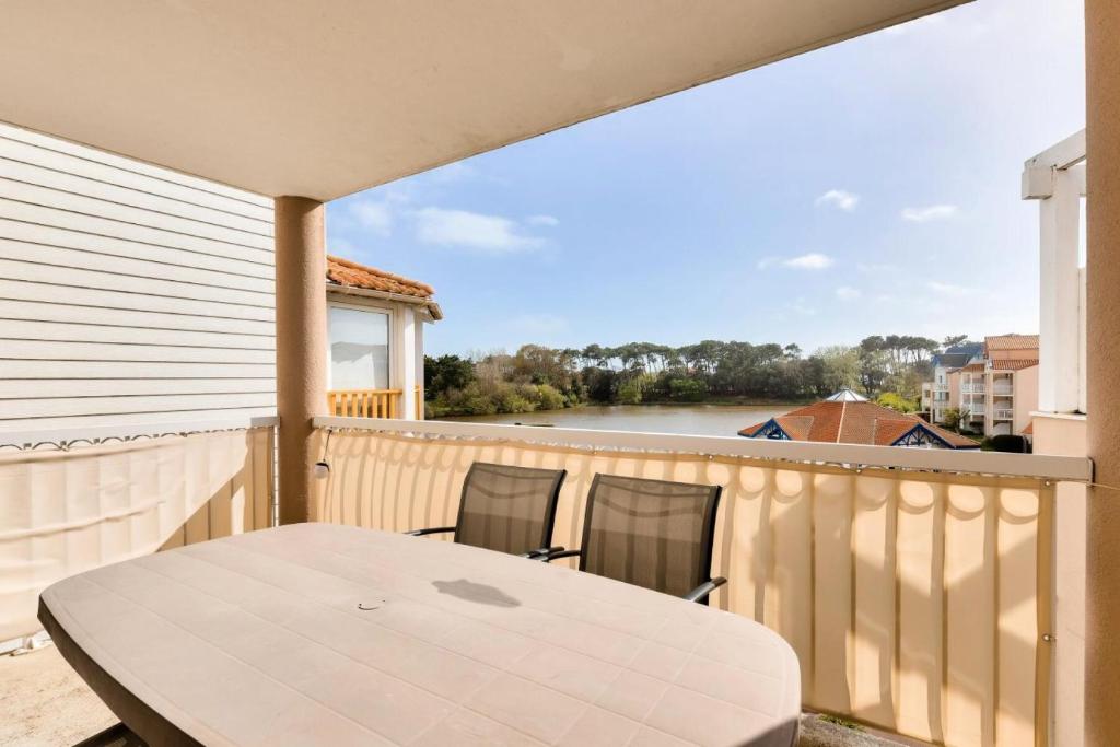 un patio avec une table et des chaises sur un balcon dans l'établissement Résidence Port Bourgenay - maeva Home - Appartement 2 pièces 4 personnes avec vue sur le lac - Prestige - super Home MAE-9654, à Talmont-Saint-Hilaire