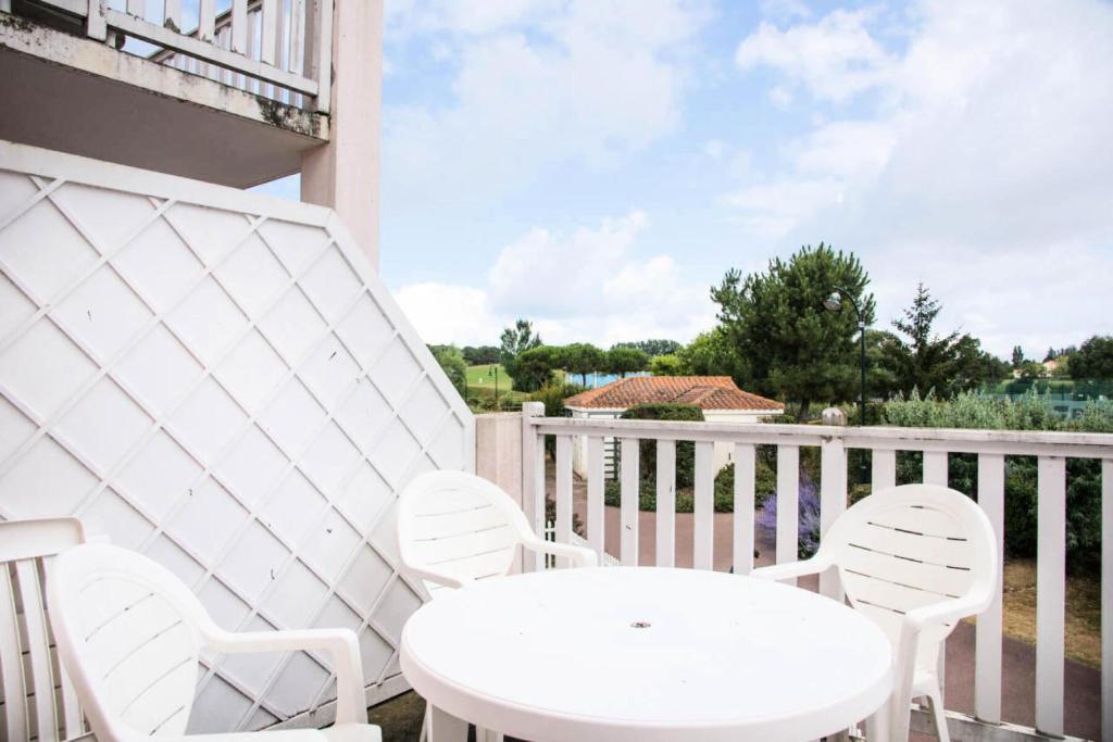 une table blanche et des chaises sur un balcon dans l'établissement Résidence Port Bourgenay - maeva Home - Appartement 2 pièces 5 personnes - Sélection MAE-9144, à Talmont-Saint-Hilaire