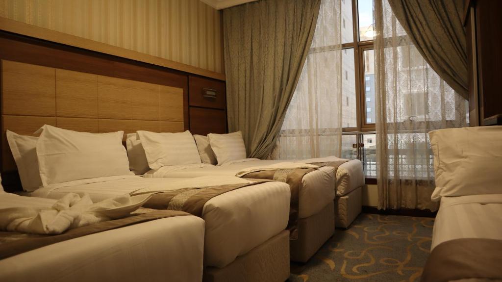 a hotel room with two beds and a window at Al Mokhtara Diamond in Medina