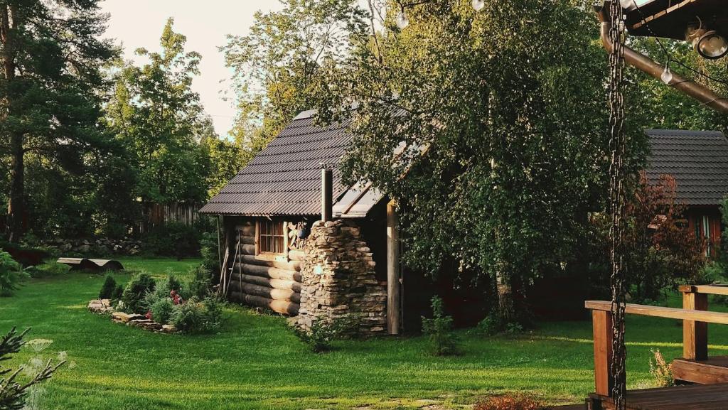 a small cabin in a yard with green grass at Uneallika hubane saunaga majake "Hoburaud" in Pae
