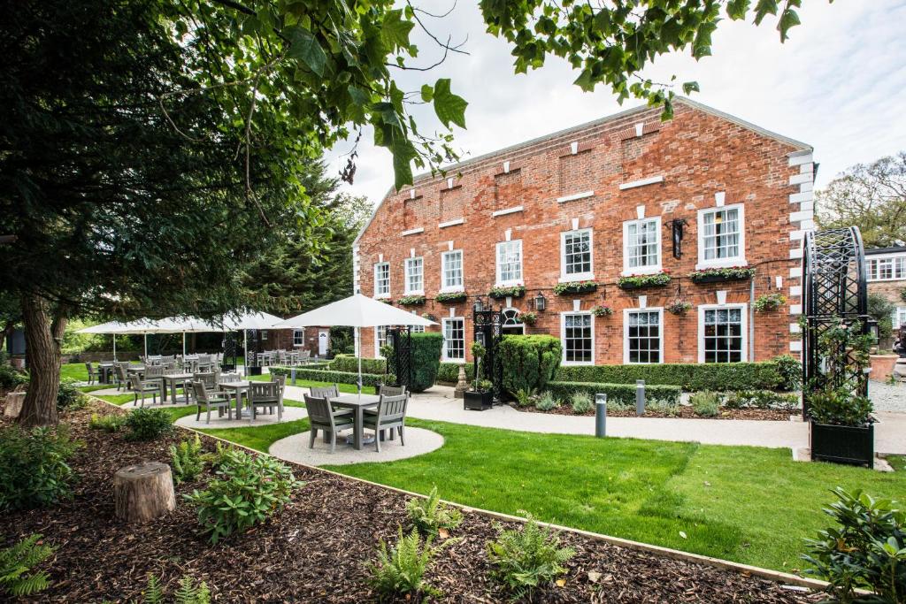 a courtyard with tables and chairs in front of a brick building at The Knaresborough Inn - The Inn Collection Group in Knaresborough