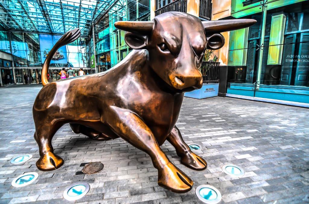 una estatua de bronce de un toro sentado en una calle en The High Trees by Night Stay, en Birmingham