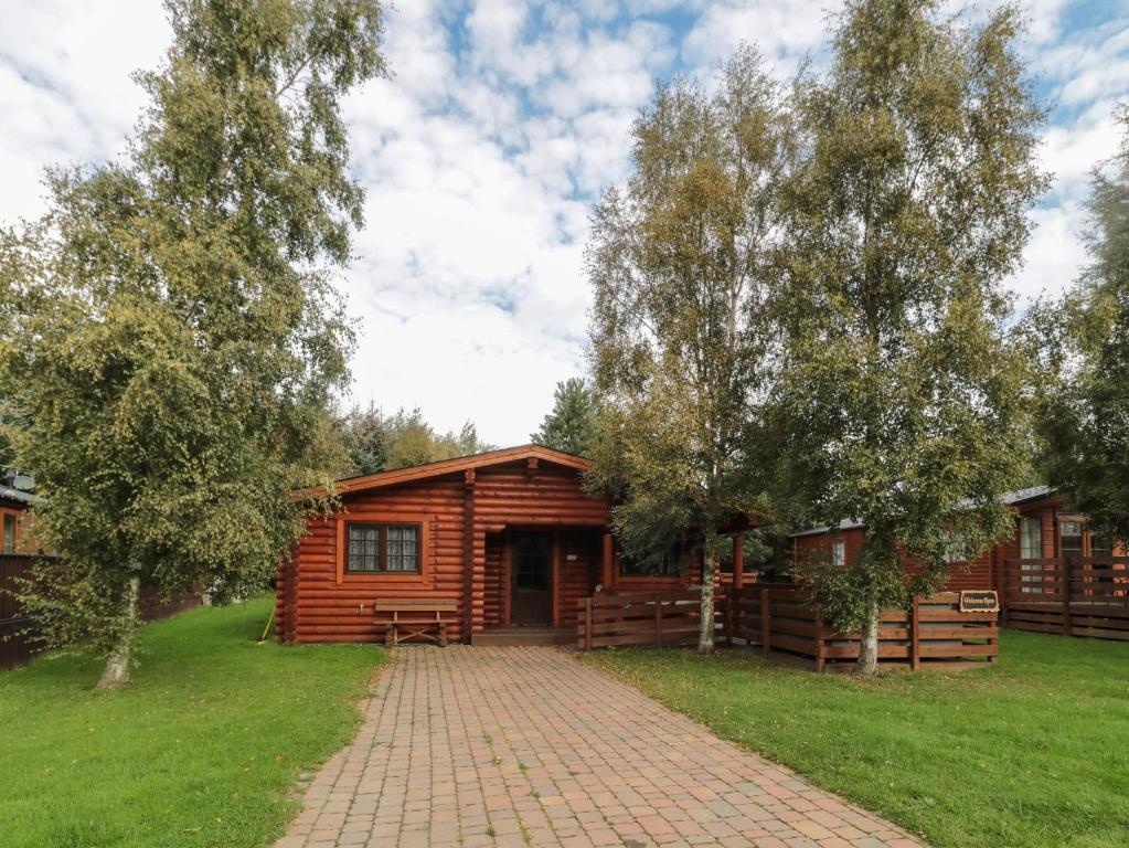 a log cabin with a brick path in front of it at Welcome Hjem Log Cabin in Morpeth