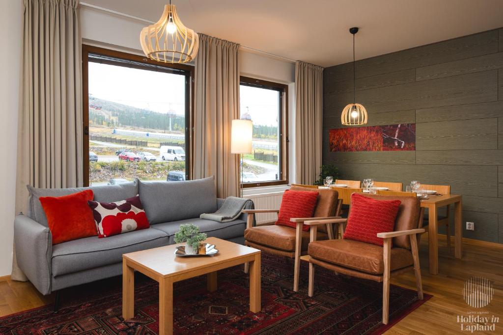 uma sala de estar com um sofá, cadeiras e uma mesa em Holiday in Lapland - Ylläs Gondola apartment, huoneisto 6207 em Ylläsjärvi