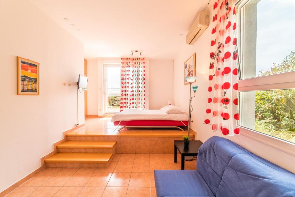 Cette chambre comprend un lit, un canapé et une fenêtre. dans l'établissement Apartments M, à Split