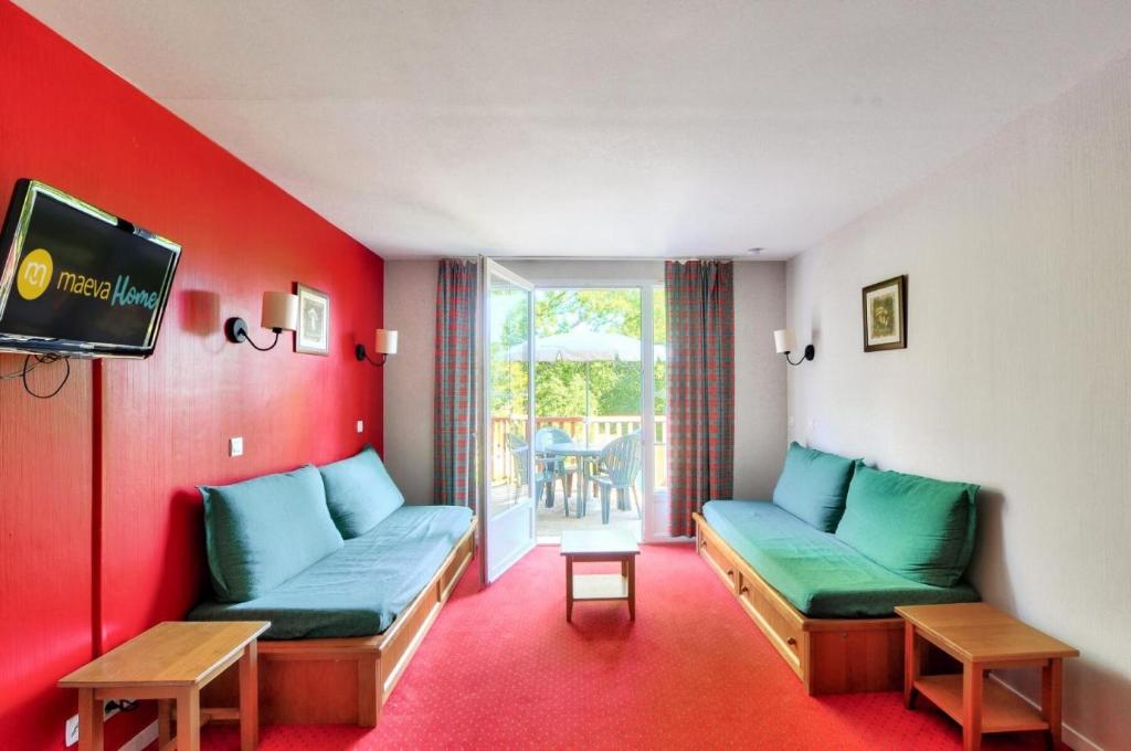 un salon avec deux canapés et une télévision dans l'établissement La résidence du Lac - maeva Home - Appartement 2 pièces 5 personnes - Sélection MAE-5404, à Monflanquin