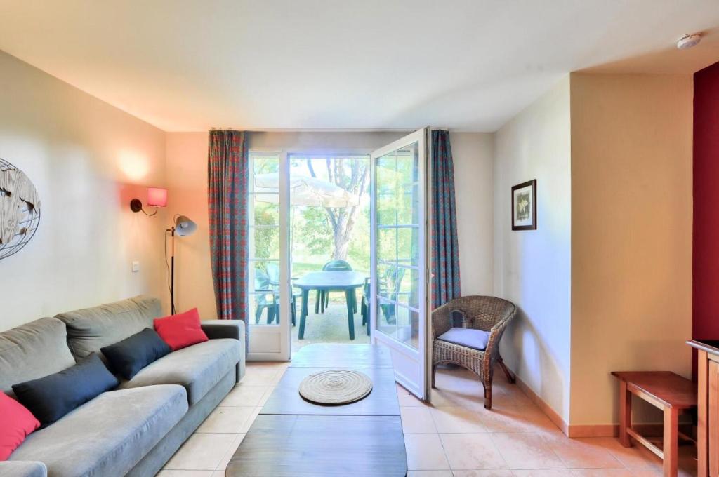 un salon avec un canapé et une table dans l'établissement La résidence du Lac - maeva Home - Maison 4 Pièces 8 Personnes - Prestige MAE-4514, à Monflanquin