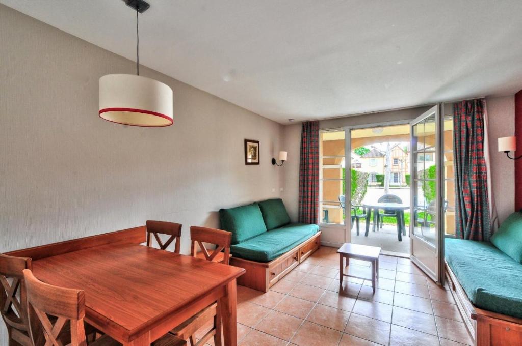een woonkamer met een tafel en een bank bij La résidence du Lac - maeva Home - Appartement 2 Pièces 5 Personnes - Sél 294 in Monflanquin