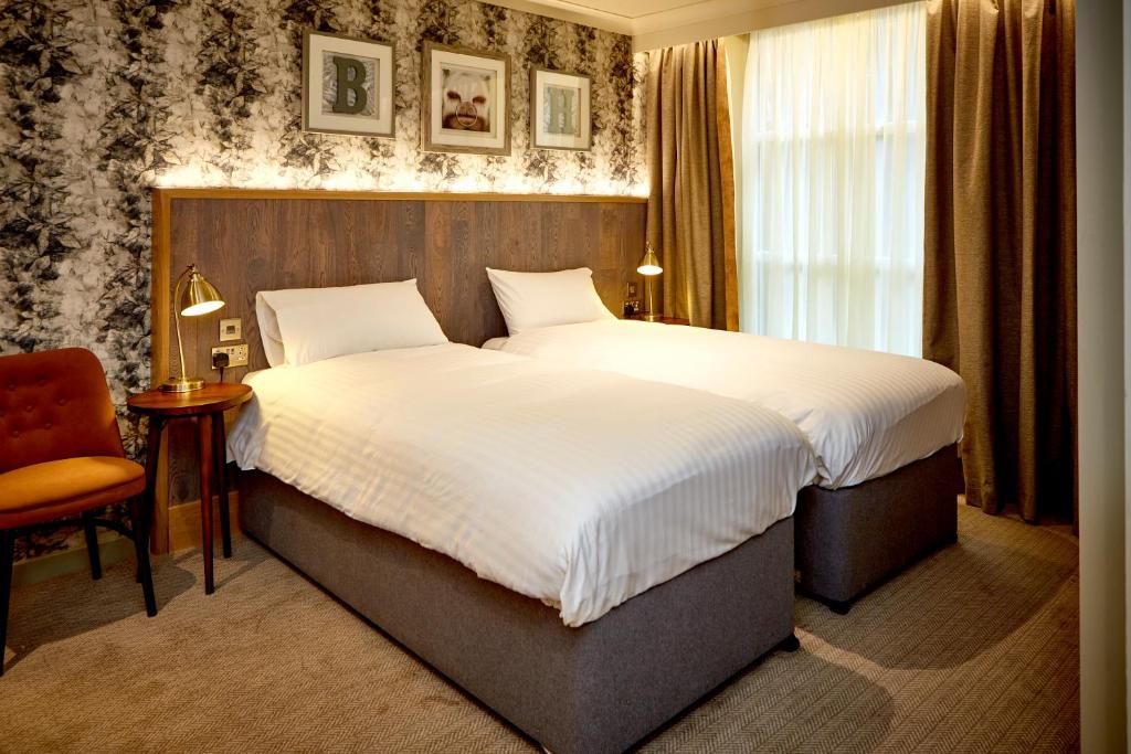 um quarto de hotel com uma cama grande e uma janela em The Belmore em Sale