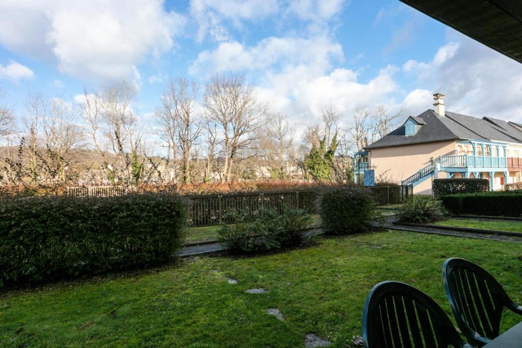 une cour avec des chaises et une maison en arrière-plan dans l'établissement Résidence Les Belles Rives - maeva Home - Appartement 2 pièces 5 personnes - Confort MAE-4334, à Argentat