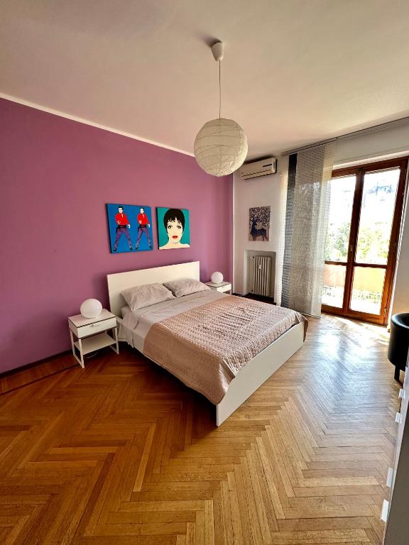 a bedroom with a bed and a purple wall at Casa Voli in Turin