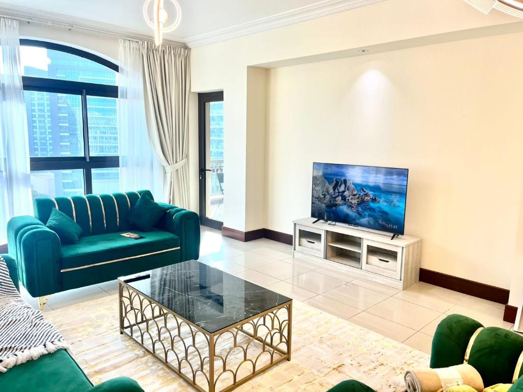 a living room with a couch and a tv at 2Bedroom Palm Jumeirah luxury Stay At Golden Mile 10 in Dubai