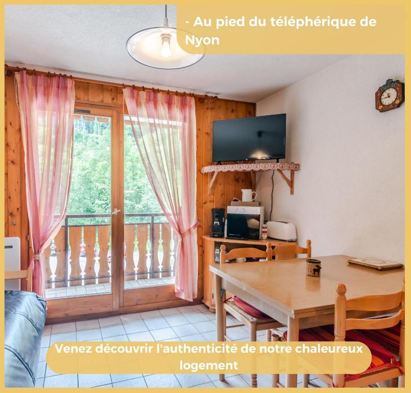 een woonkamer met een tafel en een balkon bij Appartement T2 Téléphérique de NYON Morzine in Morzine