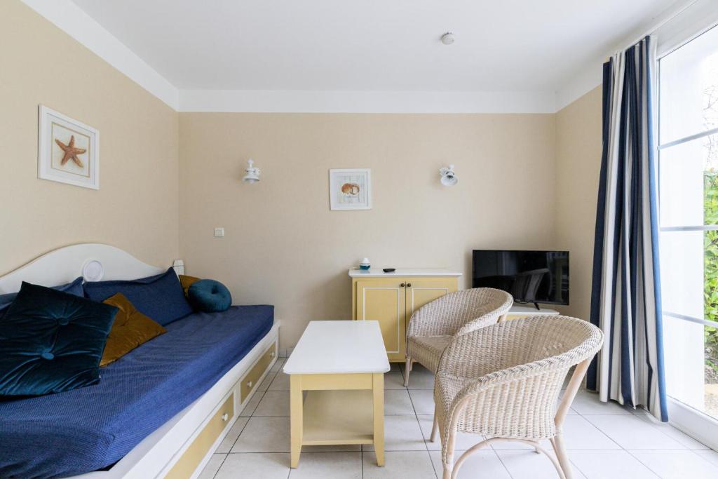 - une chambre avec un lit, deux chaises et une télévision dans l'établissement Résidence Port Bourgenay - maeva Home - Appartement 3 pièces 6 personnes - Prestige MAE-0884, à Talmont-Saint-Hilaire