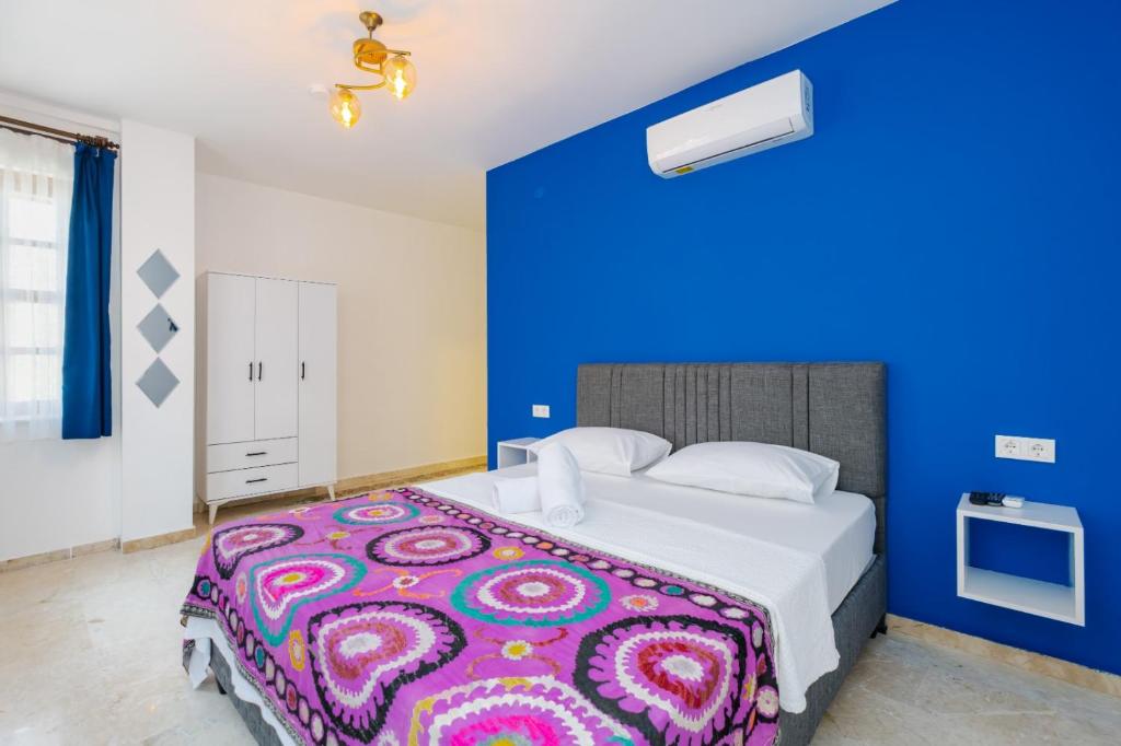 1 dormitorio con 1 cama grande y pared azul en Mel Town, en Antalya