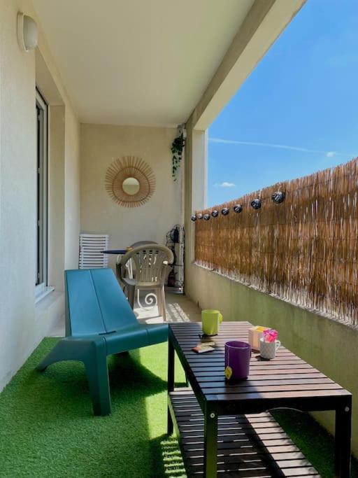 une terrasse avec une chaise bleue et une table dans l'établissement Cocon aux portes du centre ville avec terrasse, à Avignon