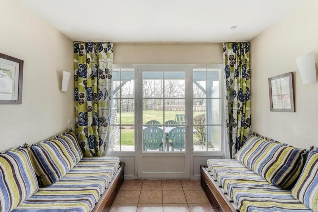 - un salon avec deux canapés devant une fenêtre dans l'établissement Résidence Les Belles Rives - maeva Home - Appartement 2 Pièces 5 Personnes - Confort MAE-5614, à Argentat