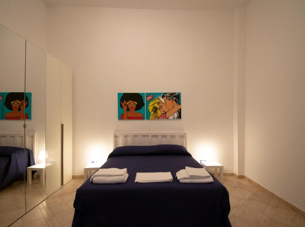 una camera da letto con un letto e due asciugamani di Tom apartments a Napoli