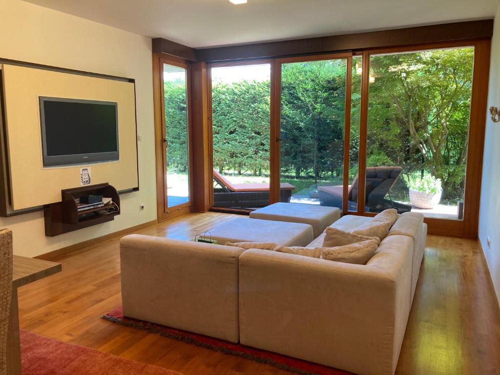 uma sala de estar com um sofá e uma televisão de ecrã plano em Aquincum Dunaparti Apartman em Budapeste