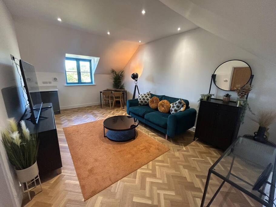 a living room with a blue couch and a mirror at Beautiful apartment in Frampton in Bristol