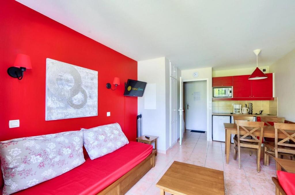 - un salon avec des murs rouges et un canapé rouge dans l'établissement La résidence du Lac - maeva Home - Maison 2 pièces 5 personnes - Sélection MAE-5764, à Monflanquin