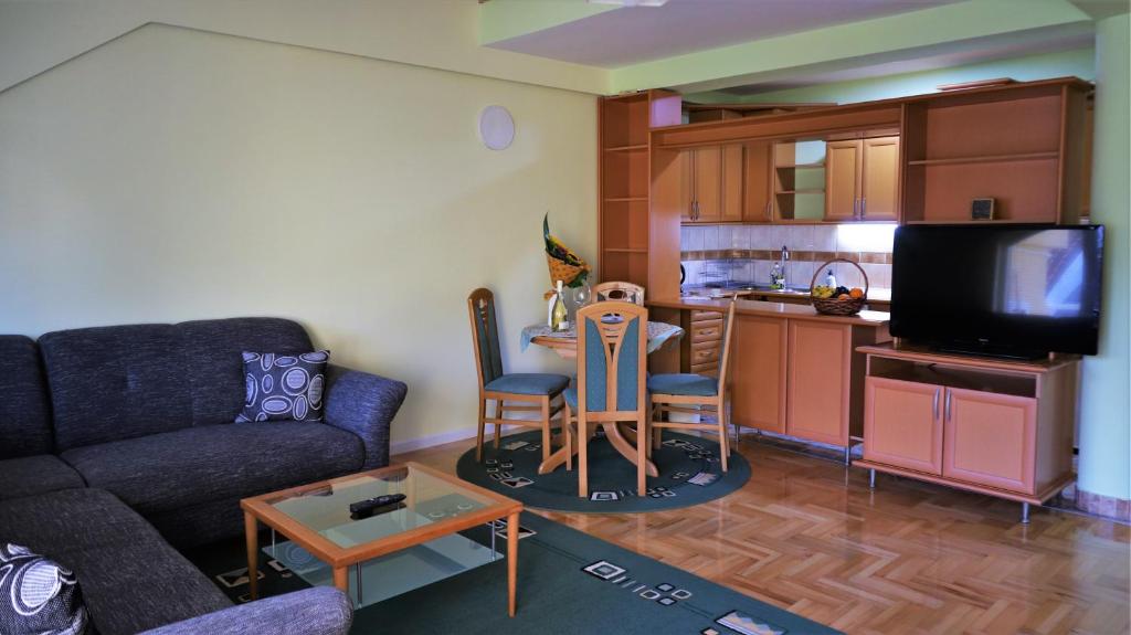 een woonkamer met een bank en een tafel en een keuken bij Spacious and quiet apartment in Skopje