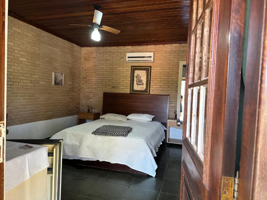 a bedroom with a bed and a ceiling fan at Old West Walter Park in Santo Antônio do Pinhal