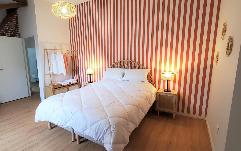 a bedroom with a white bed with red and white stripes at LA MAISON DE NOS PARENTS in Gonnehem