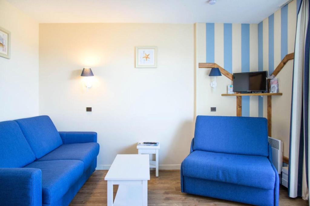 - un salon avec deux canapés bleus et une télévision dans l'établissement Résidence Port Bourgenay - maeva Home - 2 Pièces 5 Personnes Sélection MAE-2121, à Talmont-Saint-Hilaire