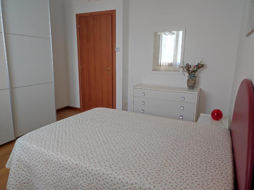 Schlafzimmer mit einem Bett, einer Kommode und einem Spiegel in der Unterkunft MARIA HOUSE for Agripolis in Legnaro