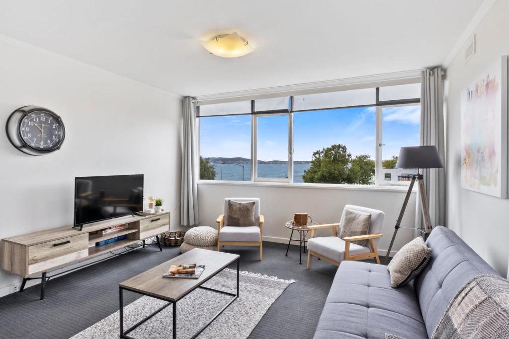 Una sala de estar con un sofá y un televisor. en Scandi-chic Riverside Hideaway Near Attractions, en Hobart