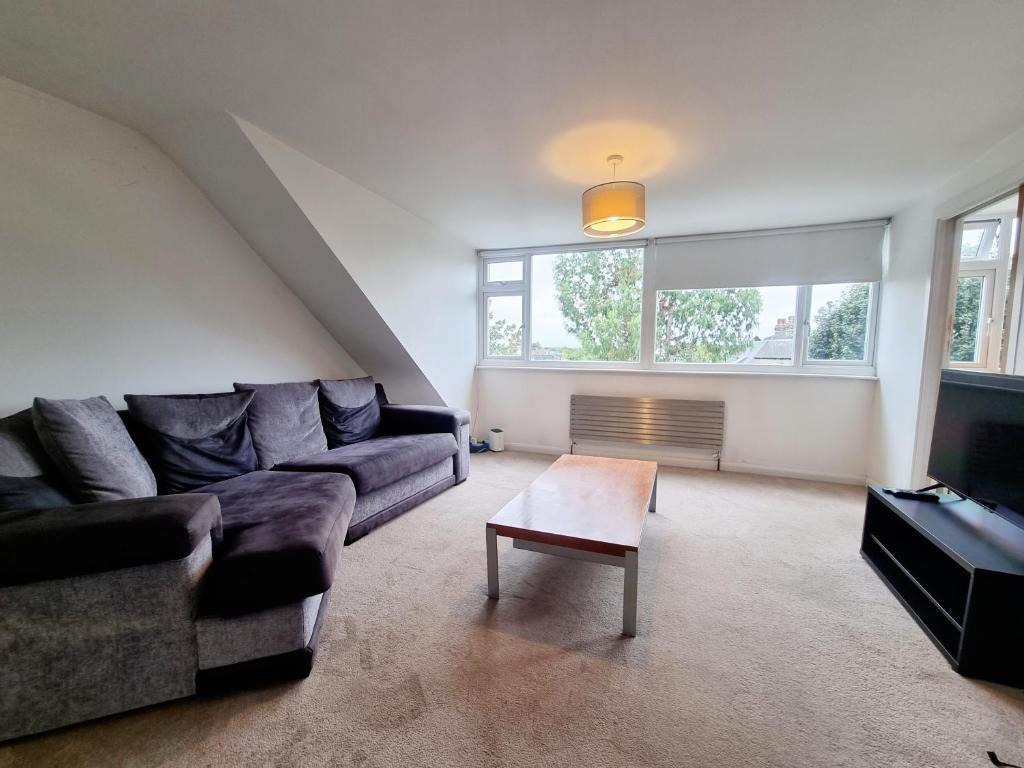 a living room with a couch and a coffee table at Bright top floor, 1 bed apartment in great location in London