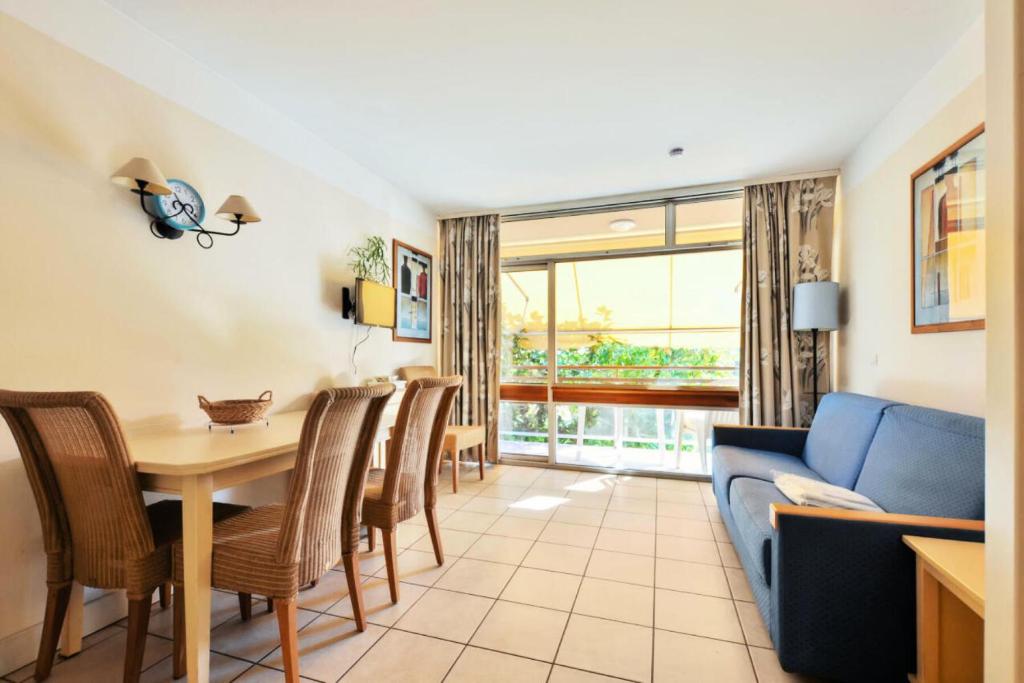 a living room with a table and chairs and a couch at Résidence Héliotel Marine - maeva Home - Studio 4 personnes - Confort MAE-5084 in Cros-de-Cagnes