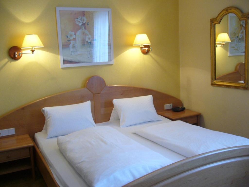 a bedroom with a bed with two white pillows at Hotel Restaurant - Häuserl im Wald Graz in Graz